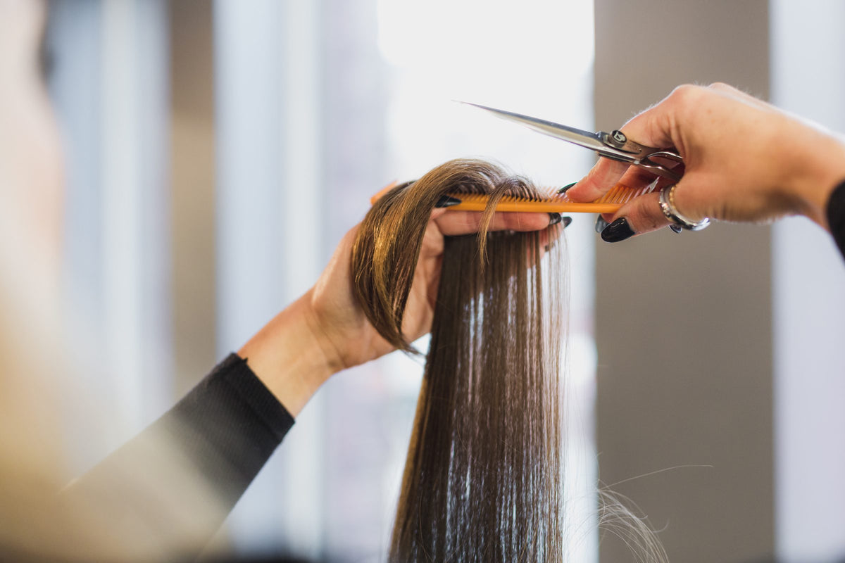 Stylist trimming long straight human hair